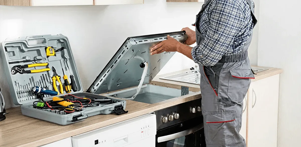 Handyman repairing a cooktop and checking wiring connections in Long Beach, CA